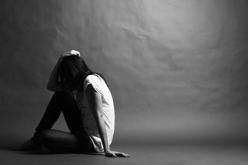 Teenager girl with depression sitting alone on the floor in the dark room - obrazy, fototapety, plakaty