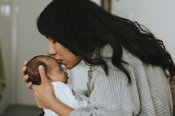 Loving mother kissing her infant baby © Rawpixel.com
