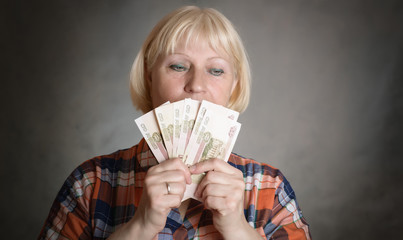 Elderly woman holds money in her hands. Selective focus on money.