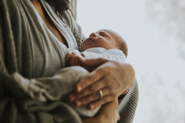 Mother holding her baby indoors © Rawpixel.com