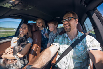 cheerful family with two children goes to the car