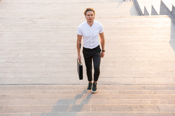 Above view of Smiling curly business man with briefcase