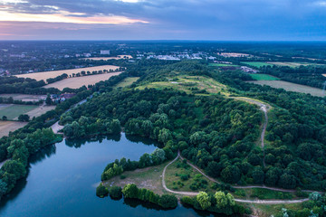 Fototapeta na wymiar Aerial view of amazing sunset over the park in Germany. Hill and lake from birds eye view. 
