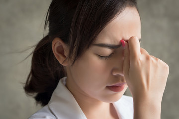 Fototapeta premium portrait of stressed and sick woman with headache; ill woman suffers from stress, vertigo, dizziness, migraine, hangover, health care concept; young adult asian woman model