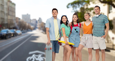 friendship, extreme sport and people concept - happy friends with skateboards over san francisco city background