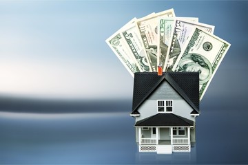 Dollar bills and house model on light background