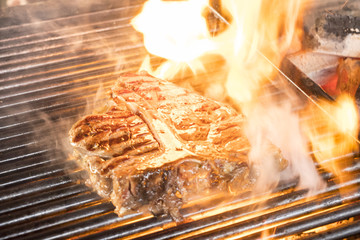 Beef steaks on the grill with flames