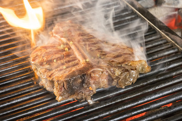 Beef steaks on the grill with flames
