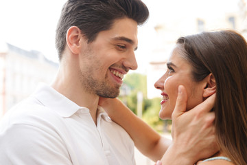 Loving couple walking outdoors while hugging.