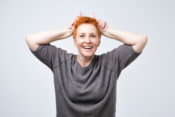 Lifestyle and beautiful people concept. Studio shot of expressive mature stylish woman with red...