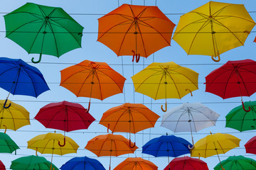 Fototapeta na wymiar Colorful umbrellas against the blue sky at the street festival