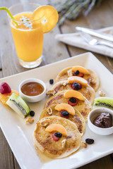 Healthy summer breakfast,homemade classic american pancakes with fresh berry and honey, morning light grey stone background copy space top view