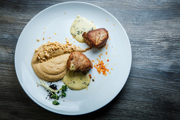 top view on two tasty pieces of grilled meat with puree and sauce