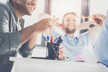 Obraz premium cropped shot of smiling young multiethnic businessmen working on new project at office, business teamwork concept