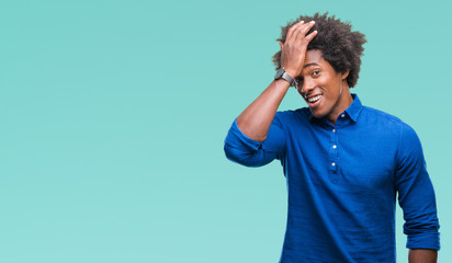 Afro american man over isolated background surprised with hand on head for mistake, remember error....