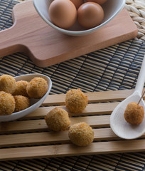 Croquetas sobre tabla de madera, e ingredientes