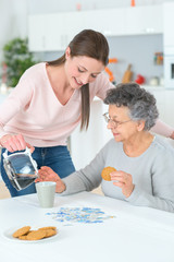 Obraz na płótnie Canvas girl serving the elderly woman with coffee