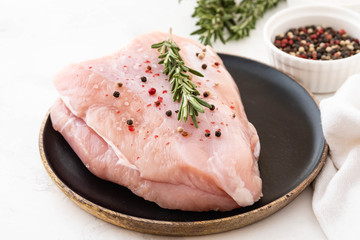 Turkey breast raw meat with spices on a dark background. Copy space.