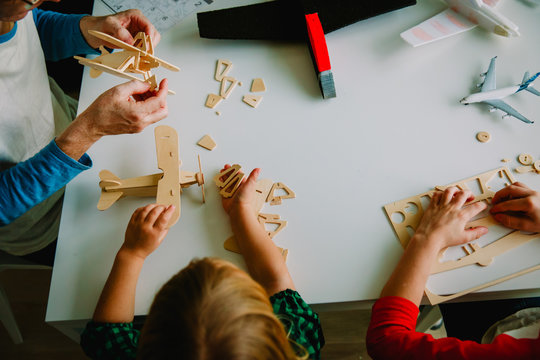 teacher and kids making toy wooden planes