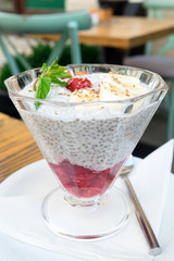 Sweet and healthy vegetarian breakfast - natural milk yogurt with chia seeds, fresh raspberry jam and fruits