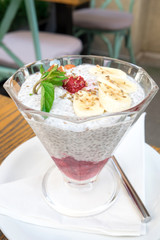 Sweet and healthy vegetarian breakfast - natural milk yogurt with chia seeds, fresh raspberry jam and fruits