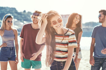 Friends on the beach. Happy young friends group have fun and celebrate while jumping and running on the beach.