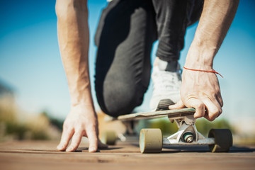 Close up of man riding longboard or skateboard in the park.