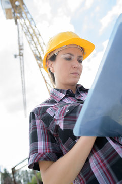 female contractor at a work site using an ipadtablet
