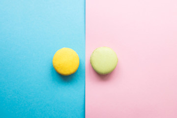 Colorful macaroons, yellow and green macaroons on blue and pink background. Copyplace, place for text.