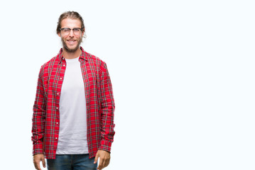 Young handsome man with long hair wearing glasses over isolated background winking looking at the...