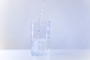 Glass of pure water on a white kitchen table