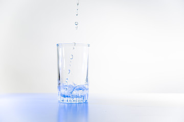 Glass of pure water on a white kitchen table