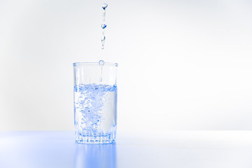 Glass of pure water on a white kitchen table