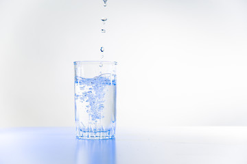 Glass of pure water on a white kitchen table