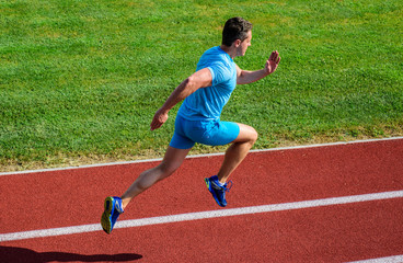 Obraz premium Athlete run track grass background. Sprinter training at stadium track. Progress and achievement. Training before take part in marathon. Man captured in motion. Sprinter athlete run training