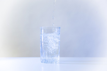 Glass of pure water on a white kitchen table