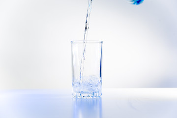 Glass of pure water on a white kitchen table