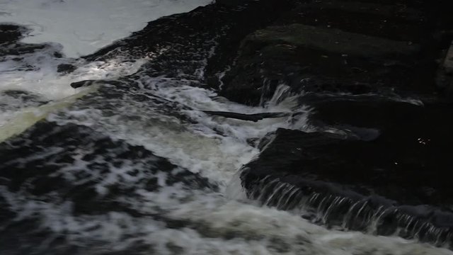 A small waterfall on the Sestra river in Klin. Close up of water and stone without grass and trees.