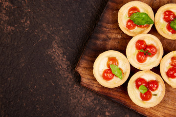 Mini tarts with cherry tomatoes with mozzarella cheese