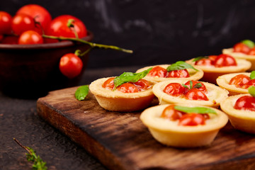 Mini tarts with cherry tomatoes with mozzarella cheese