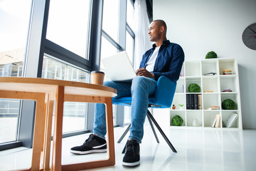 Image of african american businessman working on his laptop. Handsome young man at his desk