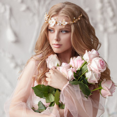 Delicate portrait of a young model girl. The image of the bride, a light lace dress in pink, a beautiful hairstyle and a natural make-up. Light photo studio, natural light from the window.