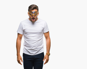 Fototapeta premium Young handsome man wearing carnival mask over isolated background afraid and shocked with surprise expression, fear and excited face.