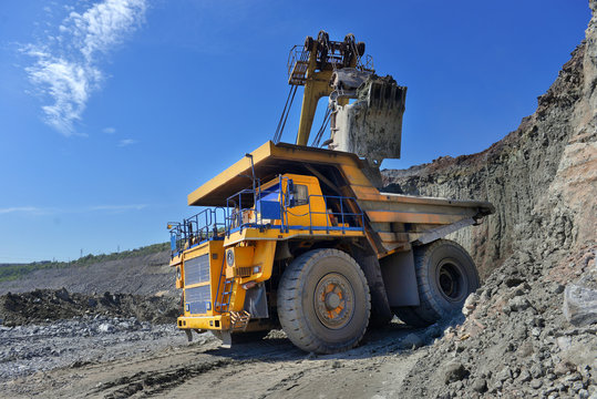 Large quarry dump truck. Loading the rock in the dumper. Loading coal into body work truck