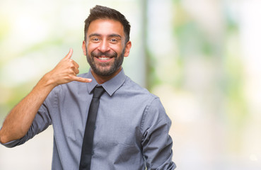 Adult hispanic business man over isolated background smiling doing phone gesture with hand and fingers like talking on the telephone. Communicating concepts.