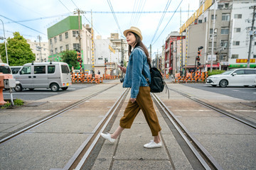 woman walking across the railroad holding phone
