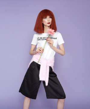 Red haired model posing with flower in vintage dress