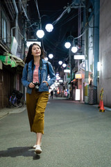 girl walking in the street holding camera