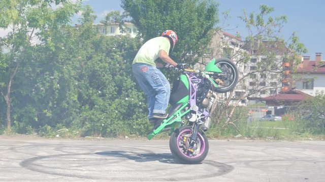 Motor show man rides motorcycle for tricks stunts entertaining public