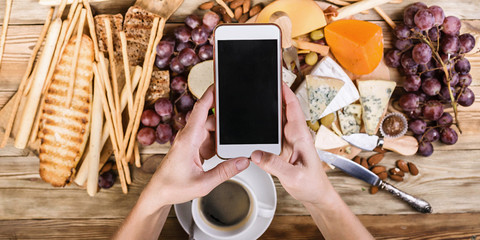 Banner. Women's hands on the smartphone take pictures of food